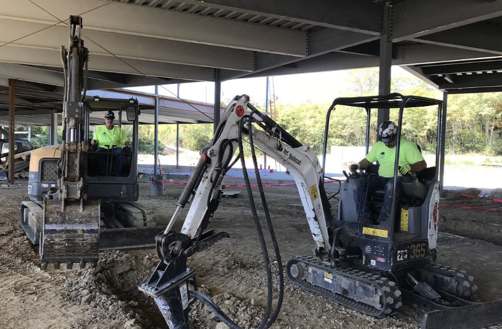 Workers digging dirt with backhoes